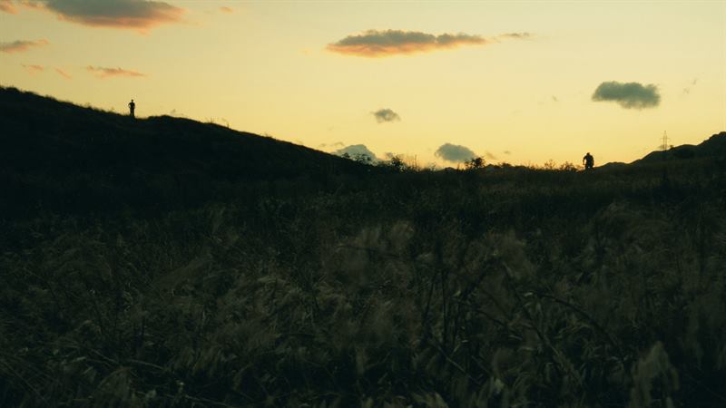 A figure on the crest of a hill against a yellow sunset