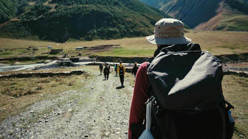 Walkers on a gravel track heading into the mountains